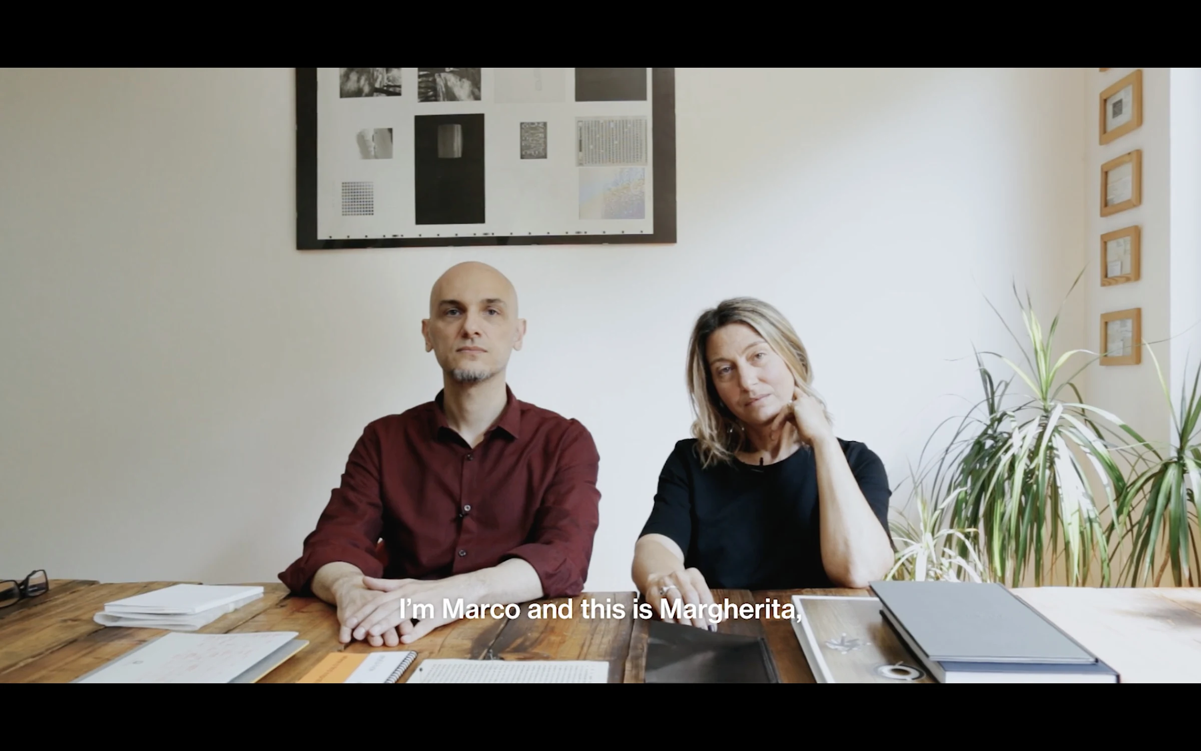 Two designers seated together at a studio table during an interview