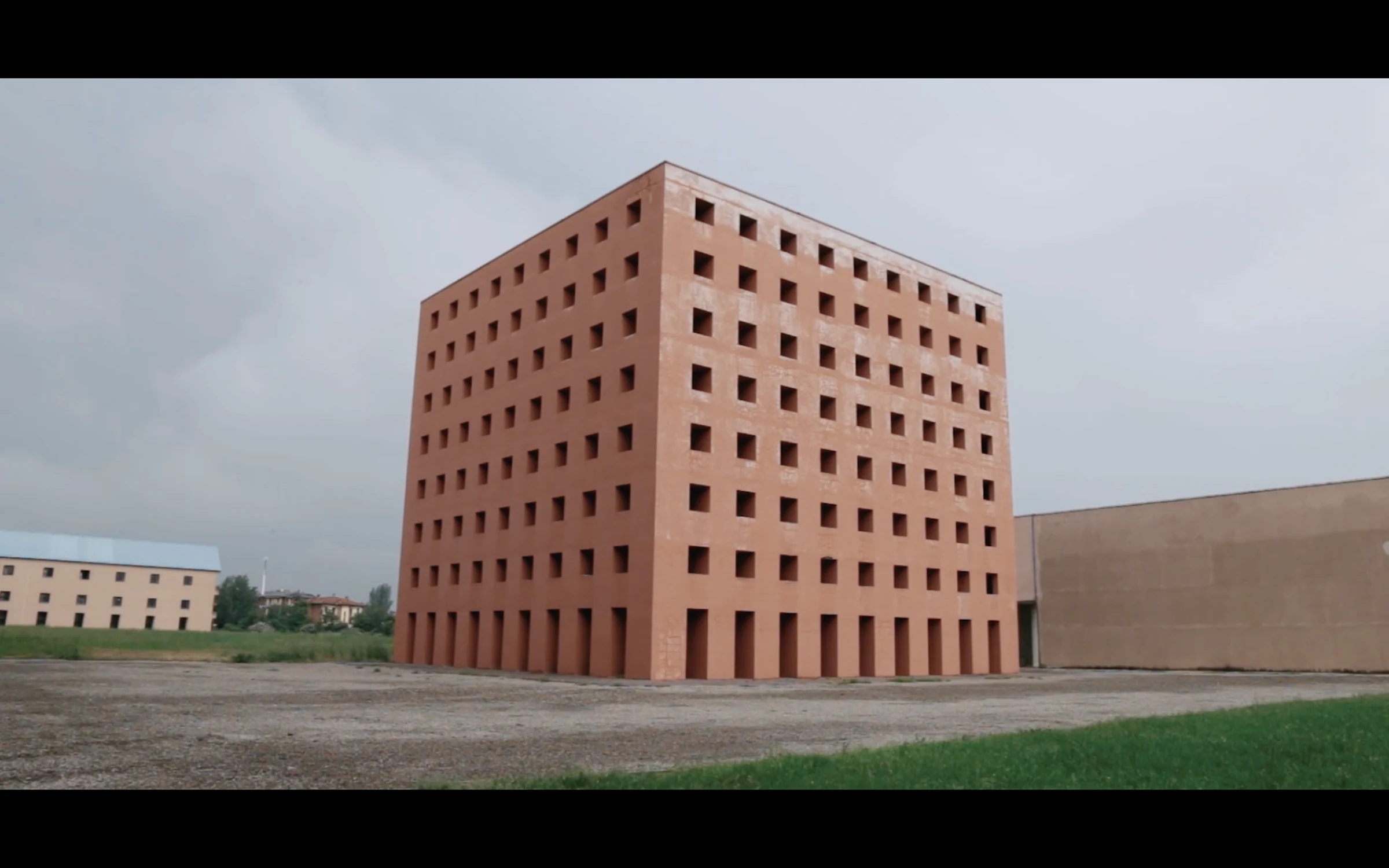 Aldo Rossi's red cube ossuary standing alone in a field